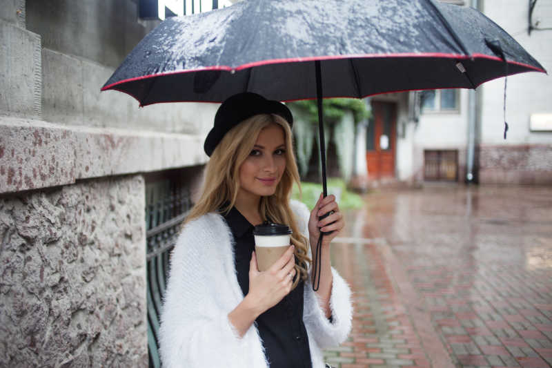 撑着伞喝着咖啡的金发美女