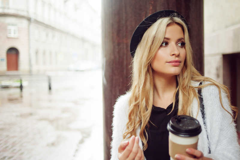 美丽的金发女郎拿着咖啡杯