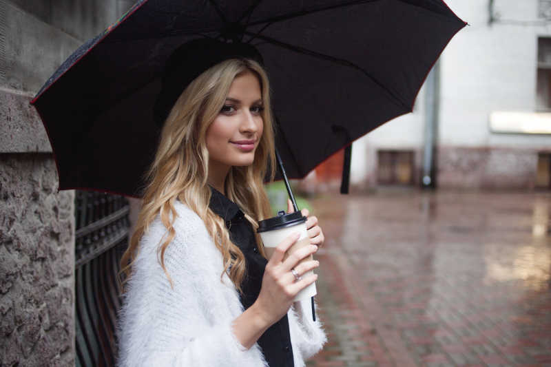 撑着上伞喝咖啡的金发美女
