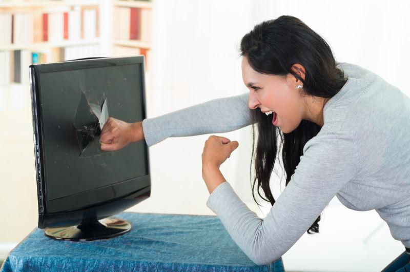 愤怒的女黑发女人打碎电脑屏幕