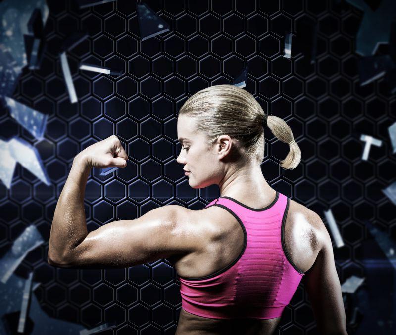 肌肉发达女人用手臂打碎玻璃