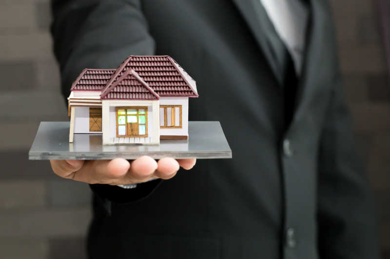 男人单手拖着房屋模型