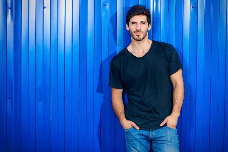 蓝色条纹墙前的时尚男人