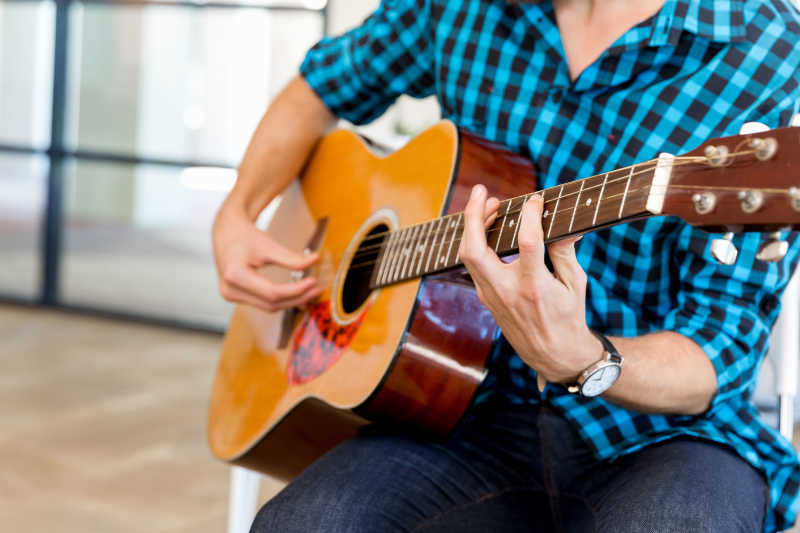 室内弹吉他的男子