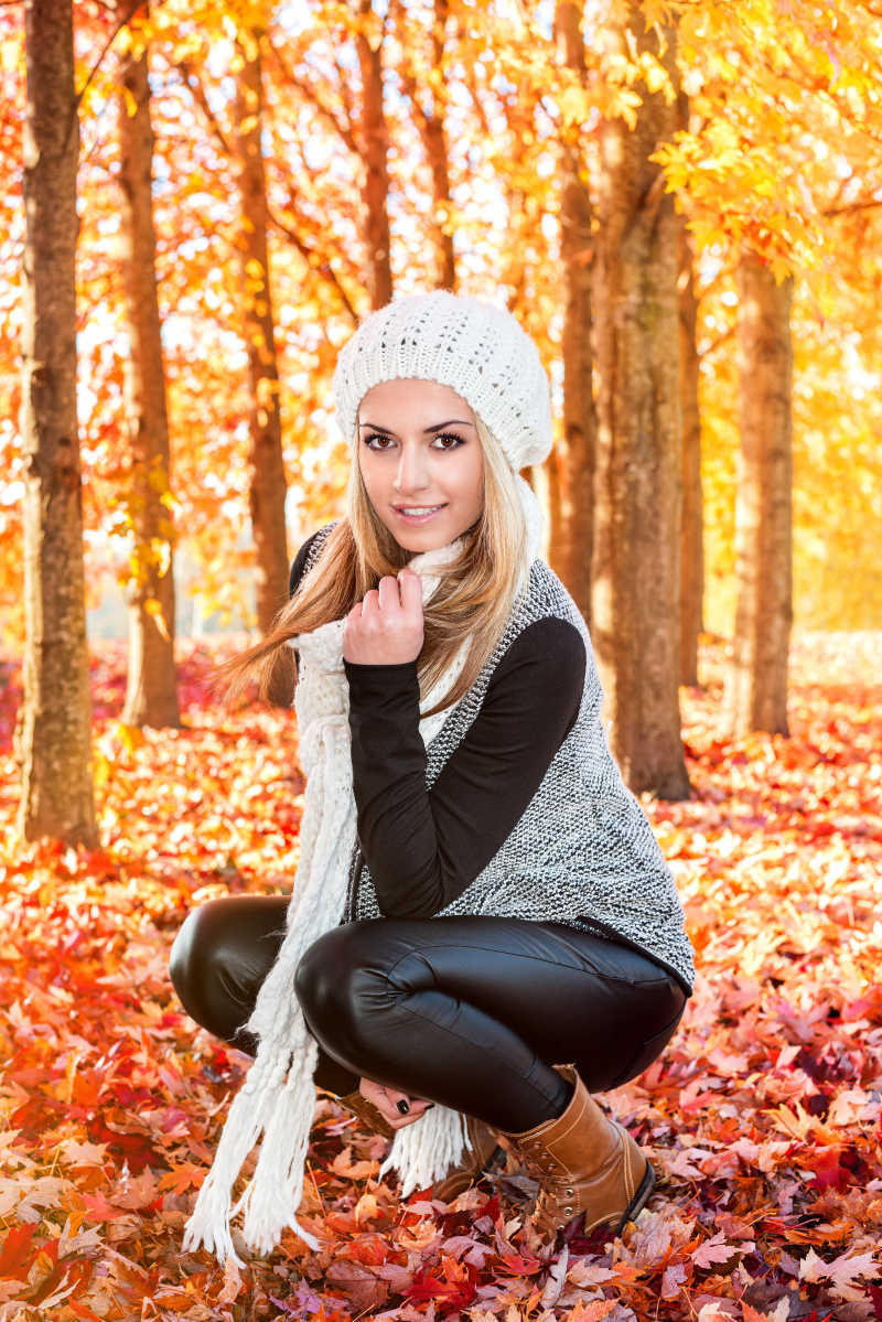 秋天树林里蹲在地上的外国美女