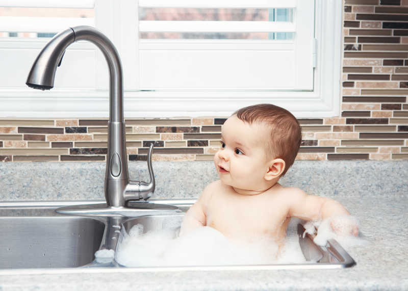 可爱的婴儿在洗碗池里