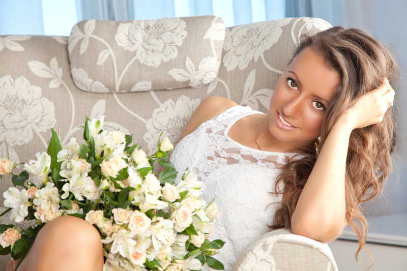 漂亮的长发女人捧着一束玫瑰