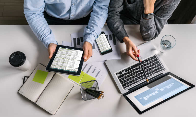 会议室里两个人正在拿着平板讨论