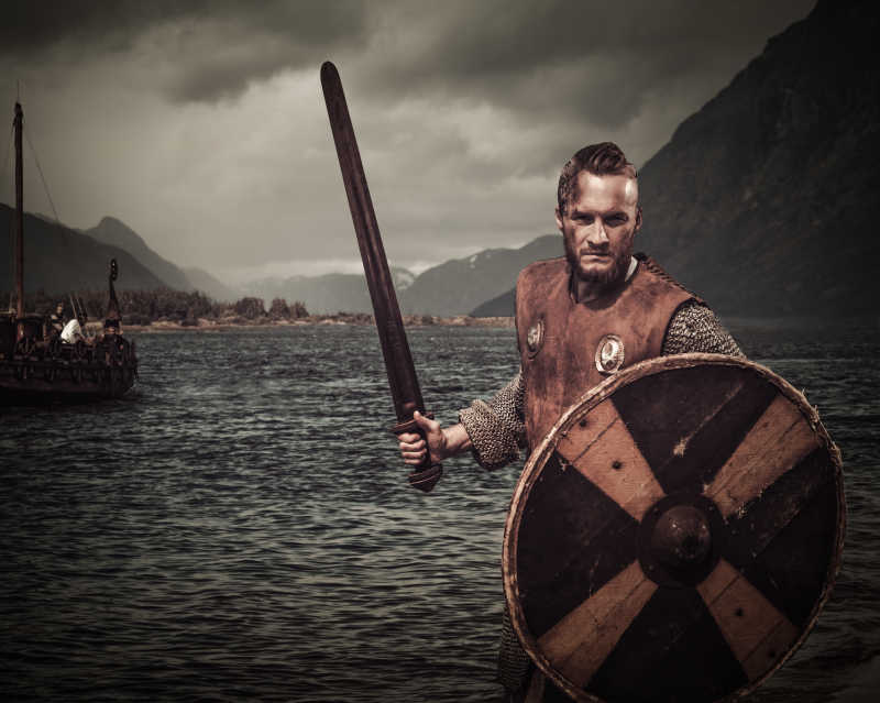 海边手持盾牌和剑的维京勇士