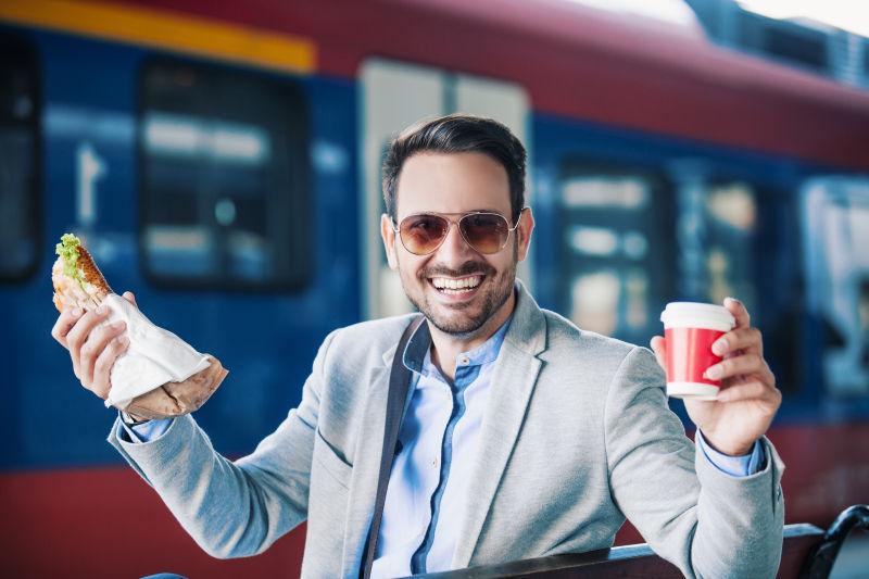 坐在火车站吃早餐的男人