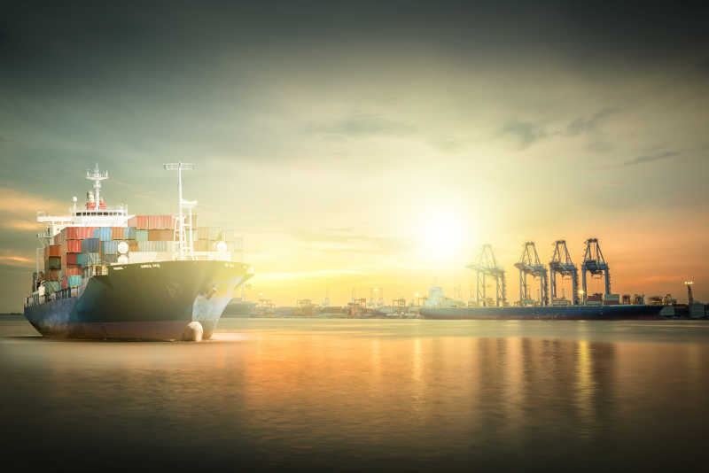 夕阳下水面上的国际集装箱货船