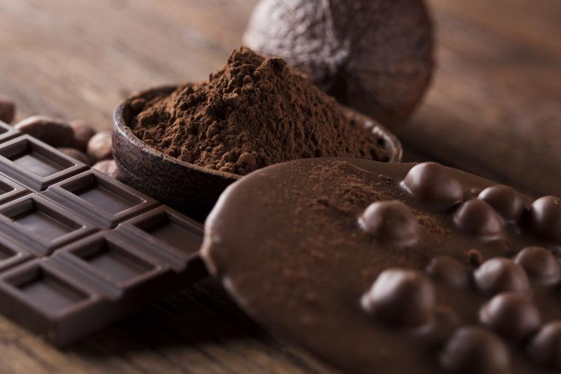 木桌上的黑色巧克力和可可粉