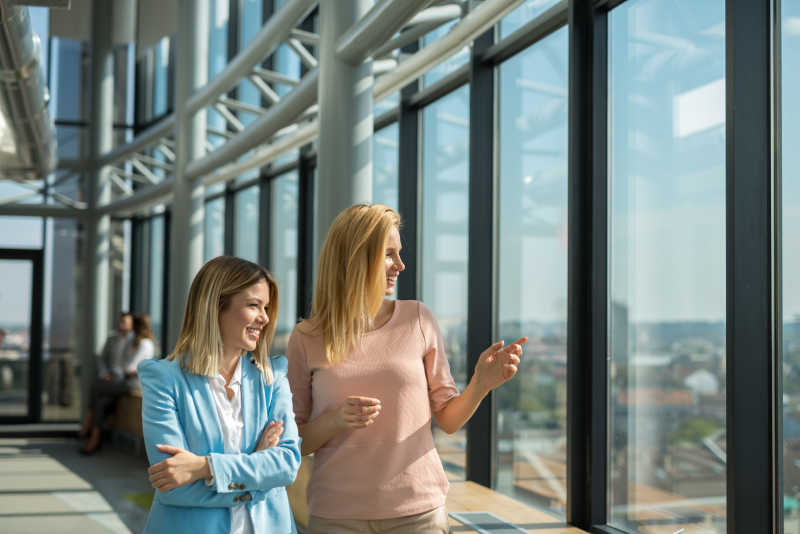 窗户边正在讨论的两个女员工