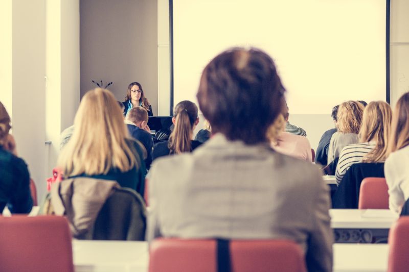 会议室里讲解的女商人和认真听讲的一群商务人士