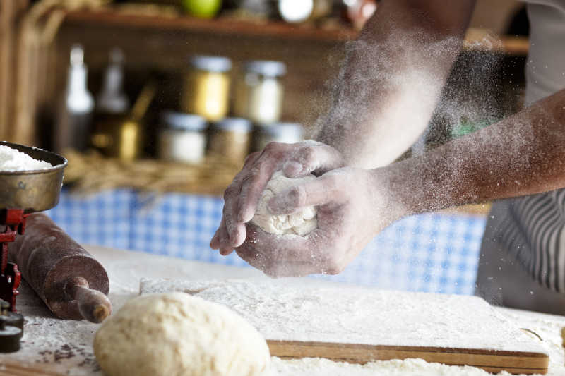 男子面包师用面粉揉搓面团做面包