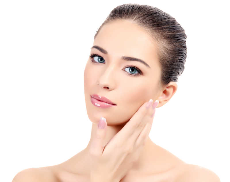 白色背景上拥有干净皮肤手抚摸脸颊的美女