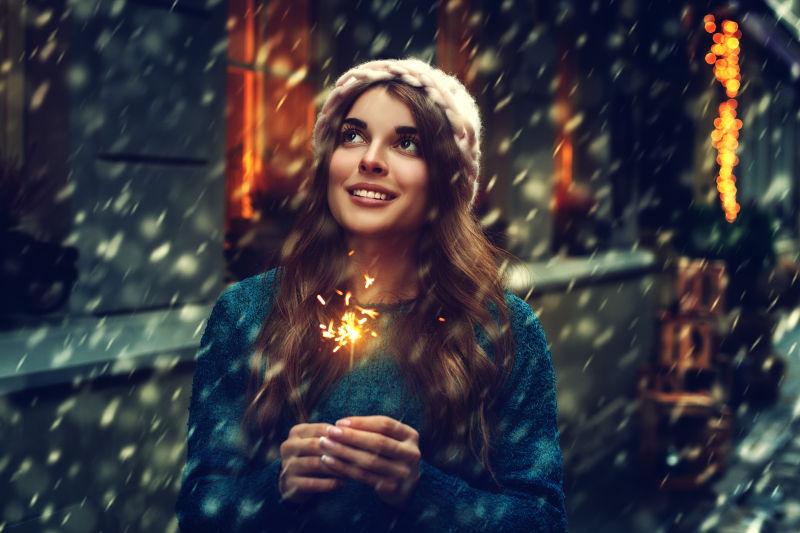 下雪背景下玩烟火的女孩