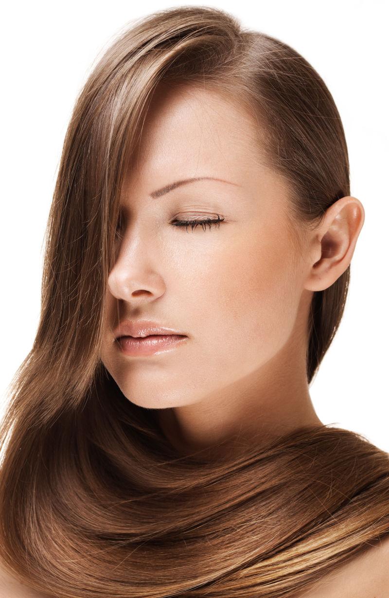 白色背景下的美丽的秀发的年轻女人肖像