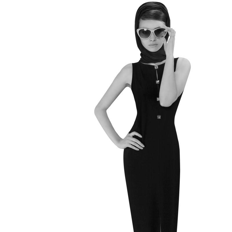 白色背景下穿着复古服饰戴着太阳镜的美女