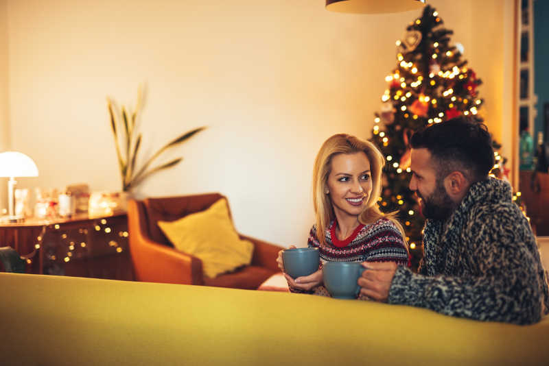 圣诞节房间沙发上的一对年轻情侣