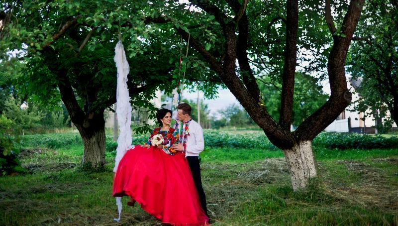 美丽的新娘坐在秋千上和新郎深情相视