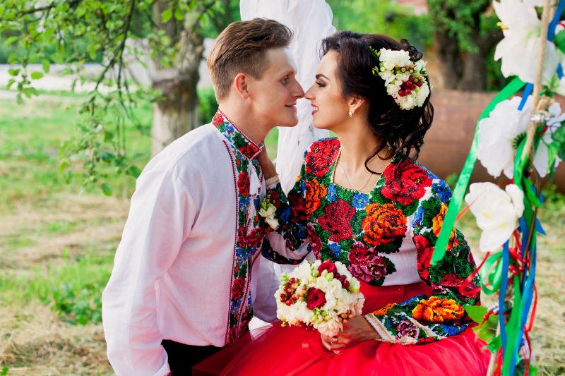 坐在秋千上接吻的新郎和新娘