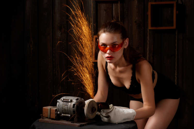 穿着黑色内衣女子在打磨斧子