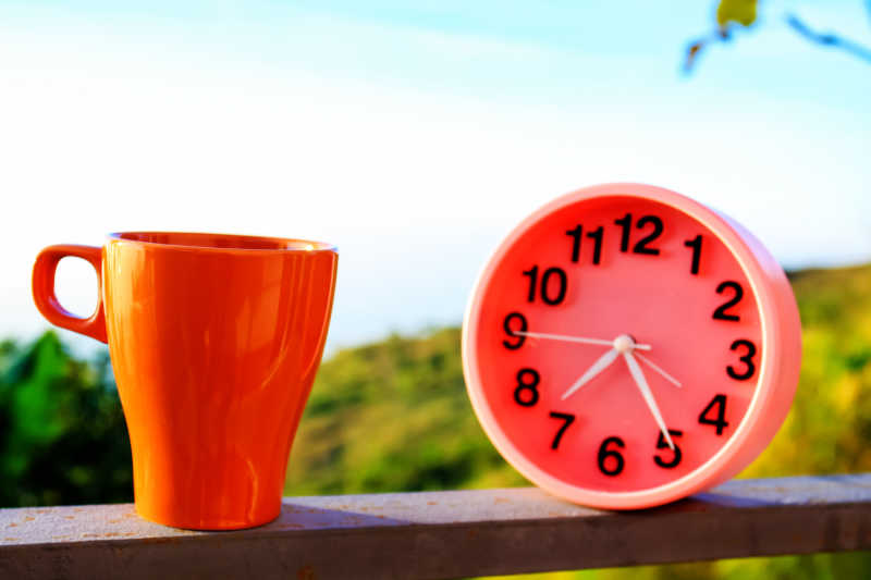 公园里的红色咖啡杯和红色闹钟