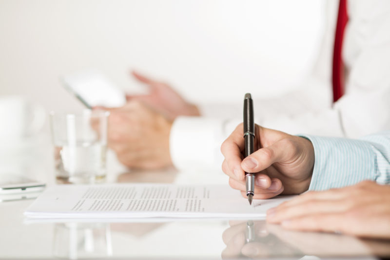 在合同上签字的男性商人