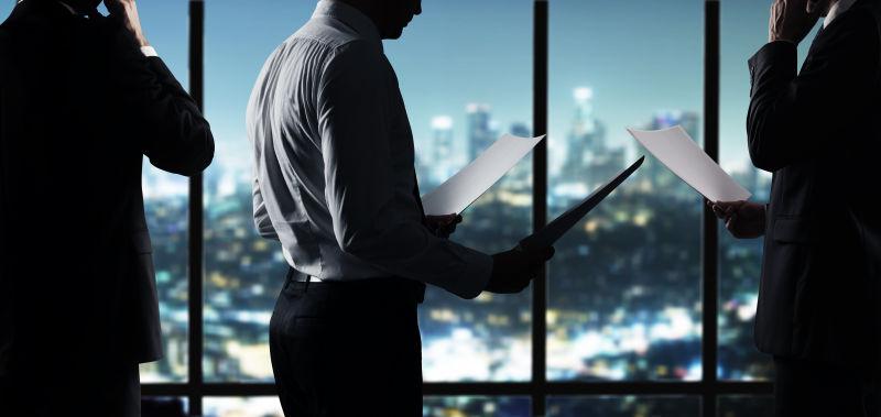 夜晚城市背景下办公室工作的商人