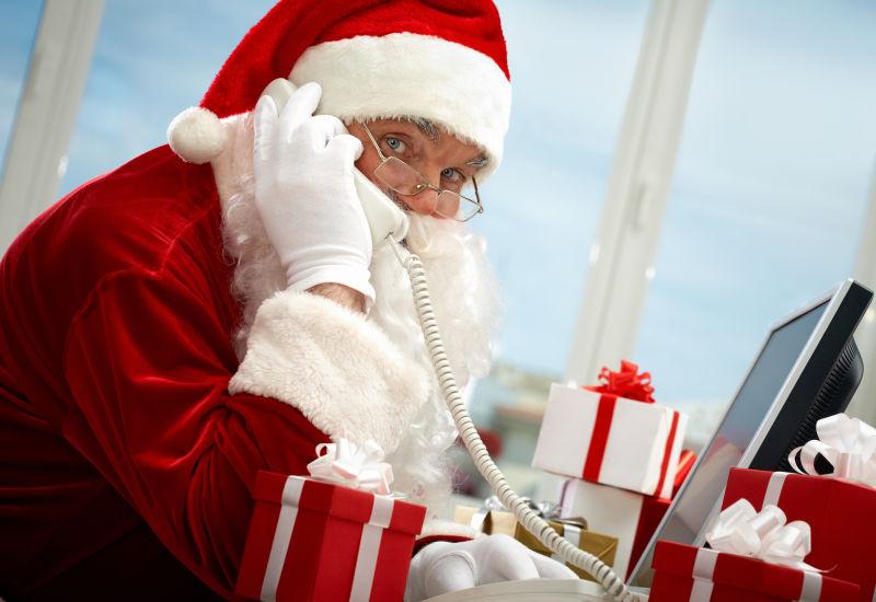 礼物背景下的打电话的圣诞老人