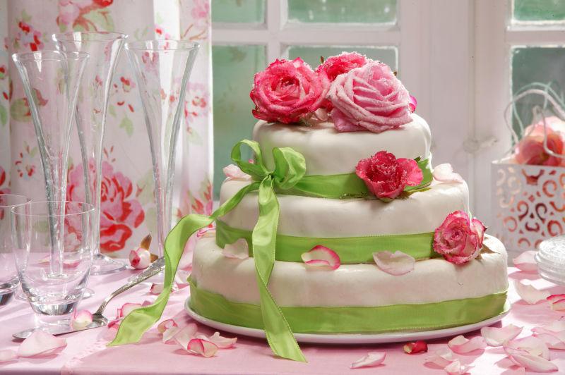 绑着彩带的有玫瑰花装饰的生日蛋糕