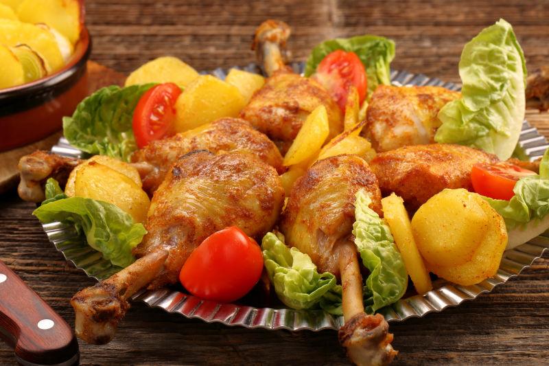 盘里的鸡腿和蔬菜烤土豆