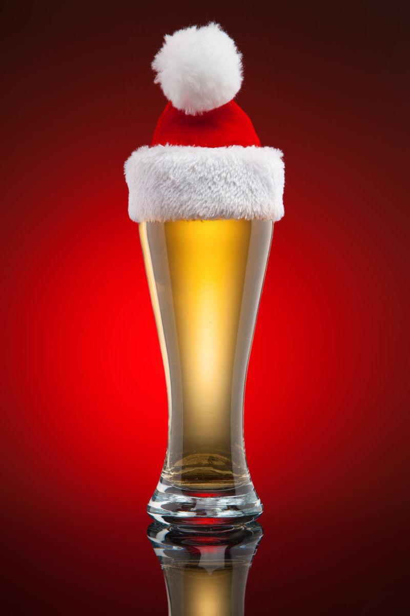 红色背景前的圣诞帽和啤酒