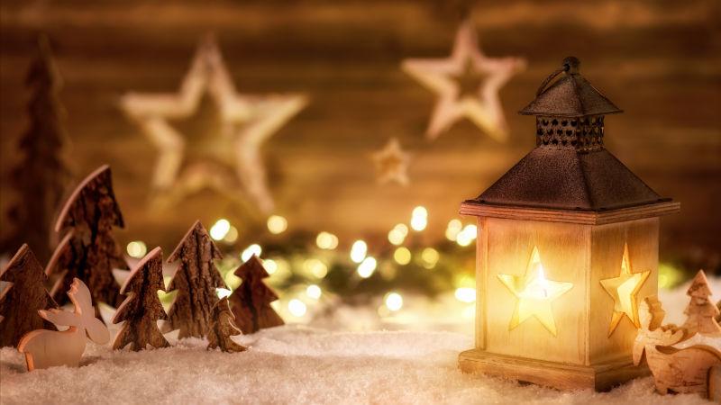 在温暖的烛光下的美丽的木制装饰物和燃烧的圣诞蜡烛