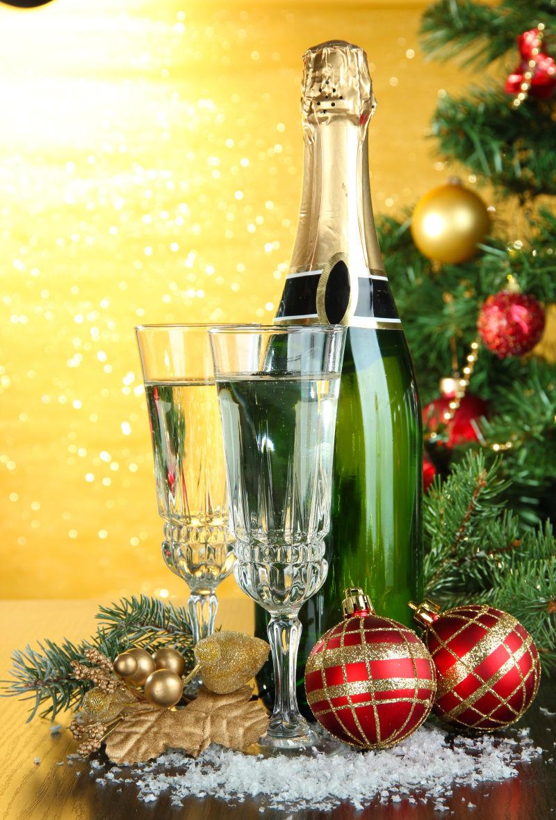 圣诞树下的香槟和高脚杯还有装饰铃铛