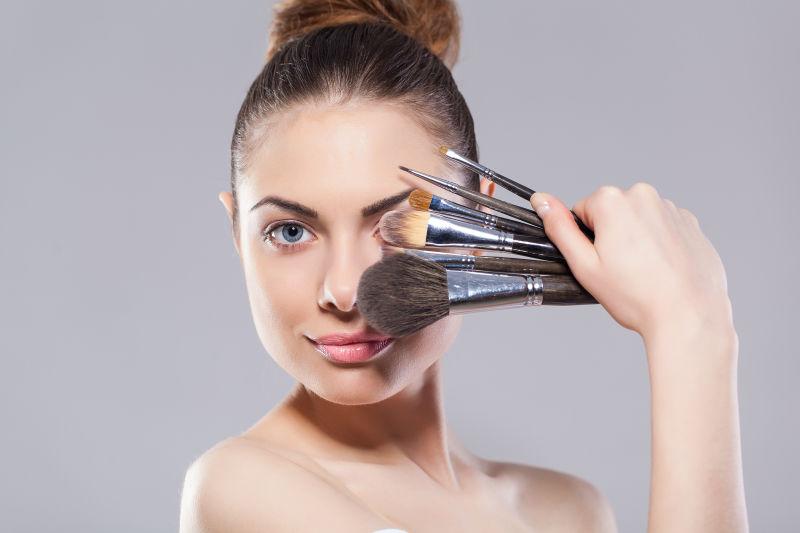 展示多种化妆刷的美女