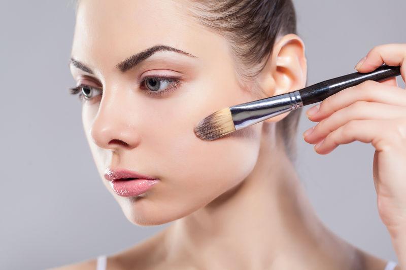 美女拿化妆刷化妆