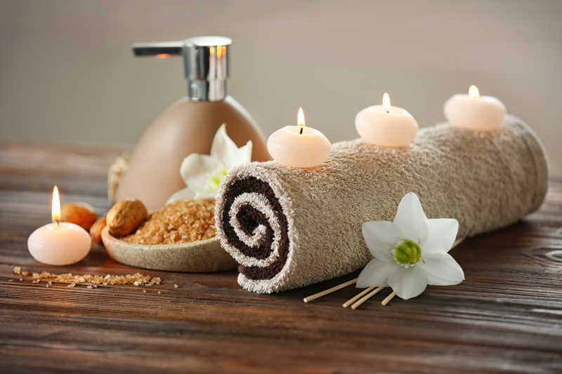 木桌上的毛巾和蜡烛水疗