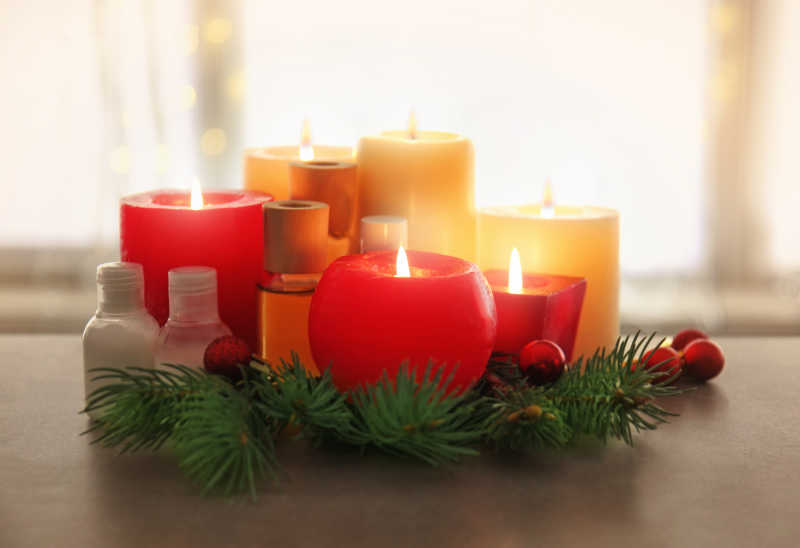 明亮的室内背景下木桌上的蜡烛和圣诞节装饰品
