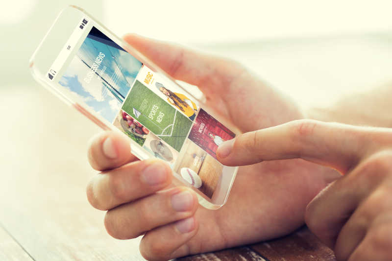 男性手持透明智能手机与互联网新闻网页的亲密接触