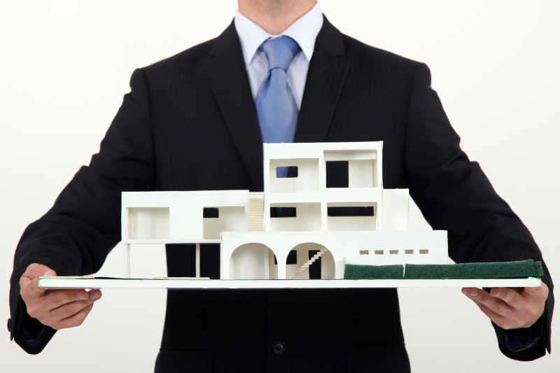 男人手上端着的房子模型