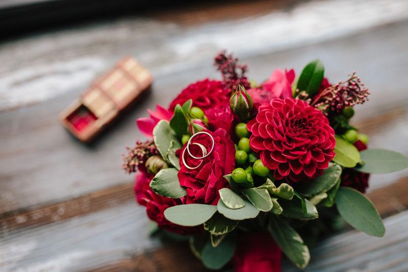 木制背景下的美丽的花环上的金戒指