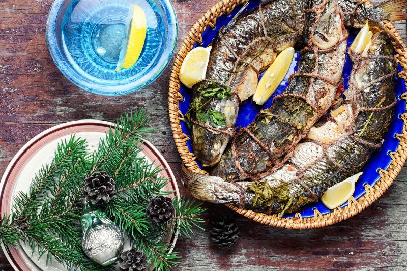 圣诞桌上的烤鱼和圣诞树装饰