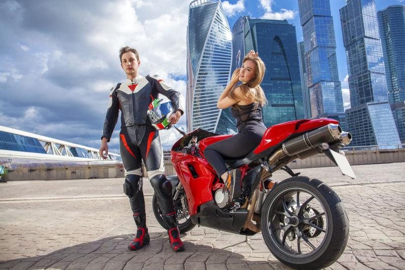 城市背景下的摩托车手和金发美女