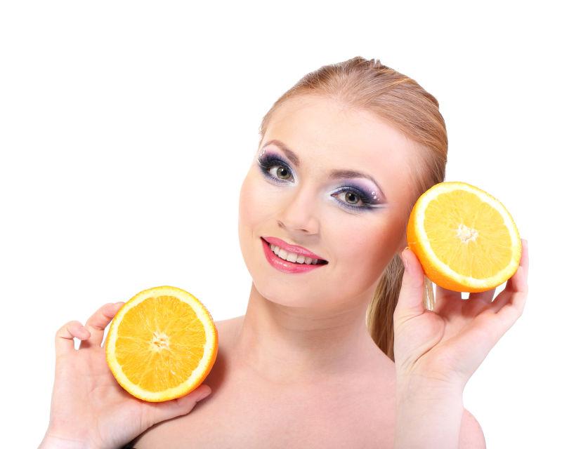 白色背景上的美女拿着橙子