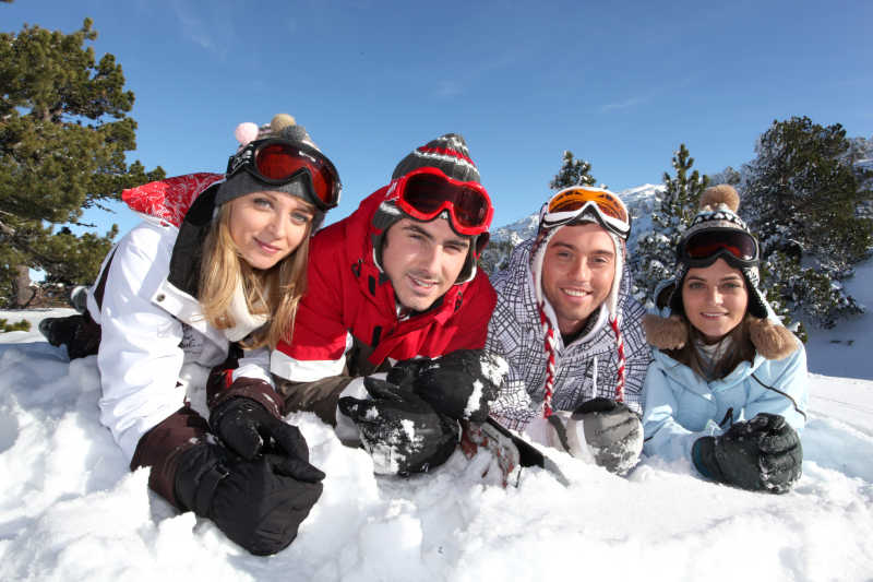 圣诞节趴在雪上的四个男女
