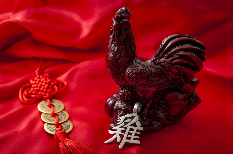 红布上的木雕公鸡和铜钱中国结