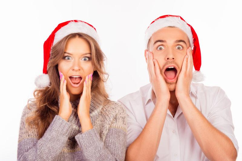 带着圣诞帽子的情侣张开嘴摆出搞怪的表情