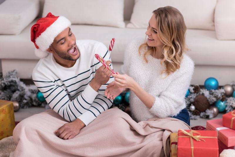 手拿圣诞糖果的年轻情侣